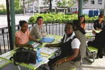 Fünf Frauen sitzen einander an einem Tisch im Freien gegenüber. Vor ihnen liegen diverse Schreibunterlagen.(Copyright Claudia Walther)